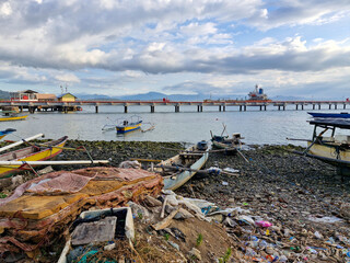 Piles of rubbish and broken boats on the beach