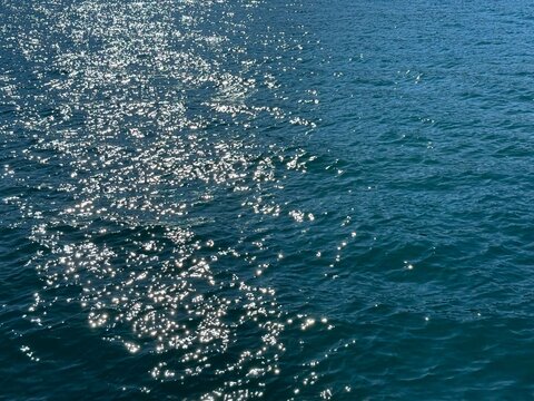 Sea blue shiny surface with sun reflections.