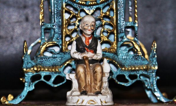 Anciano elegante y paciente esperando sentado y apoyado en su bast&oacute;n