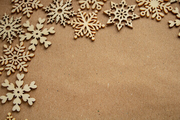 Wooden snowflakes on craft paper, frame on the left, top view