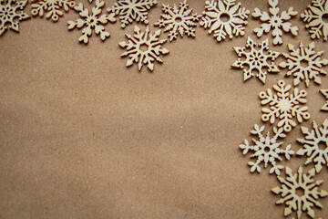Wooden snowflakes on craft paper, frame on the right, top view