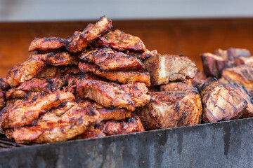 Street food. Grilled meat and side dish on a large pan for sale at the market