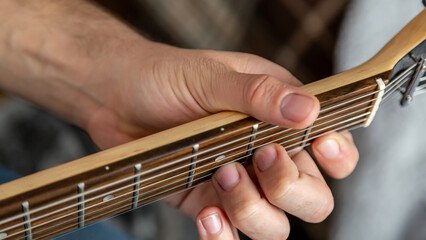 Guitar music. The performer plays. Practice chords. Male performer hands with fingers studying...