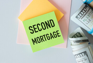Notepad with text Second Mortgage lying on financial tables with a money