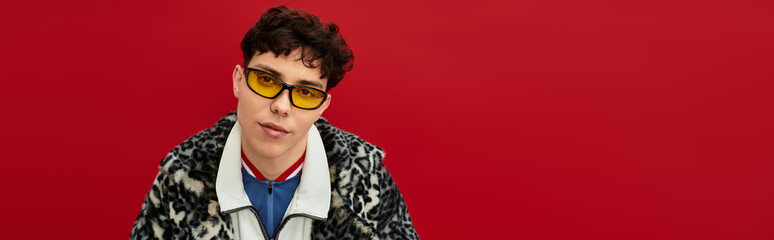 Confident individual showcases unique fashion against a bold red wall, exuding urban charm.