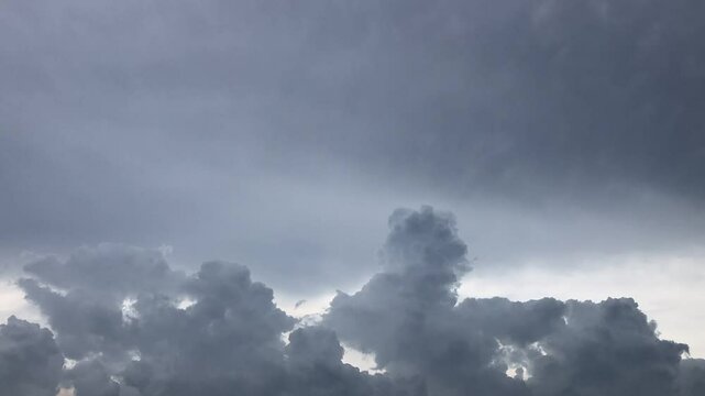 Movement of Beautiful dark rain storm clouds reveals the sun, thunderstorm in dramatic sky, with lens flare. Climate cloudscape scenic. Weather tropical summer squall.