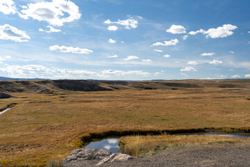 Scenic Meadow and Stream Under a Cloud-Filled Sky in Yellowstone National Park.