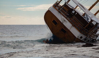 Captivating image of a shipwreck leaning on rocks in a rough sea during sunset, creating a dramatic...