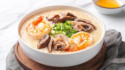 Khao porridge concept. Creamy seafood congee topped with shrimp, mushrooms, and green onions, served in a white bowl on a wooden board.