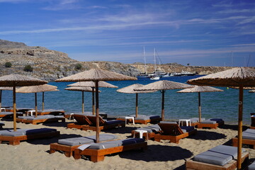 lounge beds and sunshades on Lindos bay sandy beach