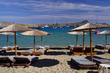 lounge beds and sunshades on Lindos bay sandy beach