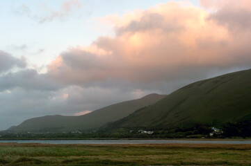 Naklejka premium A beautiful mountain range with a cloudy sky in the background