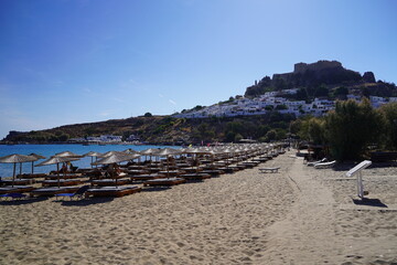 lounge beds and sunshades on Lindos bay sandy beach