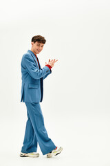 A suave man in a bright blue suit walks with flair, radiating style and charisma.