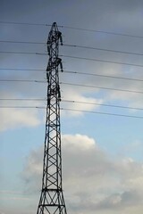 Pylône électrique devant un ciel nuageux