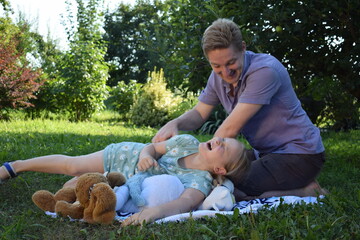 A young father spends quality time with his children outdoors in the backyard, engaging in a playful tea party with stuffed animals. The scene highlights family bonding, imagination, and joy.