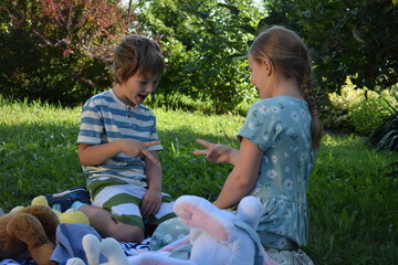 A young father spends quality time with his children outdoors in the backyard, engaging in a playful tea party with stuffed animals. The scene highlights family bonding, imagination, and joy.