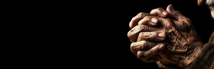 Fototapeta premium Close-up of the wrinkled hands with fingers crossed of an old man in prayer, classical gesture of a person praying God in the Christian religion on black background with copy space. Generative Ai.