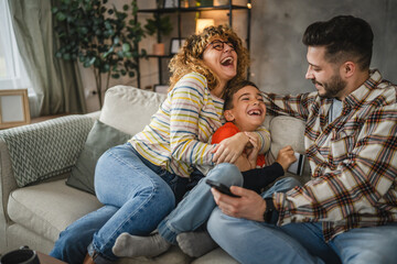 mum, dad and son shop online on mobile phone and have fun together
