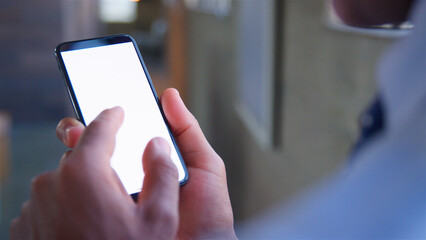 Over The Shoulder Close Up Shot Of Businessman Using Blank Screen Mobile Phone