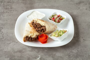 Beef burrito with salsa and guacamole.