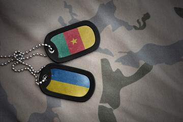 army blank, dog tag with national flag of cameroon and ukraine on the khaki texture background....