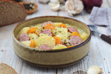 A bowl with traditional German potato soup with sausages