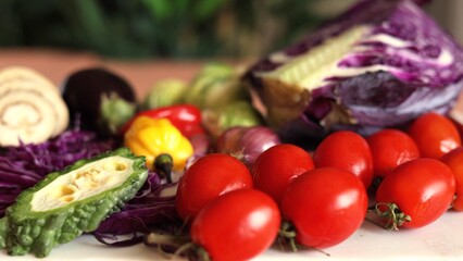 Mixed vegetables like red tomatoes, yellow peppers, purple cabbage, and green leafy greens create colorful eco display. Organic ingredients promote natural sustainable lifestyle.