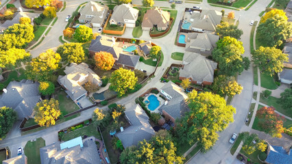 Suburban houses with swimming pools surrounding by colorful fall foliage in Coppell, suburbs...