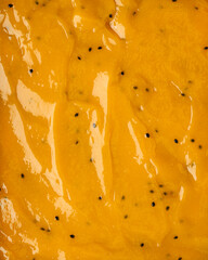 Passionfruit, mango jam texture with pulp in a close up on the surface. Bakery dessert concept. Full frame delicious background.