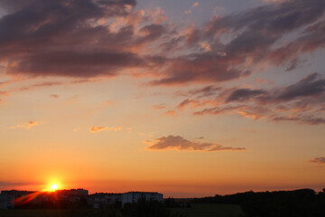 Sunset over the city. Sunset sky clouds landscape, cityscape. Dramatic sky nature, golden hour. Cloudiness, cloudscape. Orange, yellow sundown sky, outdoors, evening time.
