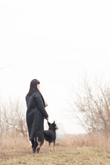 Woman walking her dog in the park on a foggy day