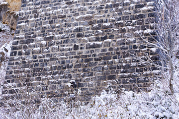 Close-up of stone pier of famous railway Landwasser Viaduct at Albula Valley in the Swiss Alps on a snowy autumn day. Photo taken November 22nd, 2024, Filisur, Albula Valley, Switzerland.