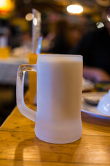 Frozen beer mug on wood table, refreshing drink after work hard