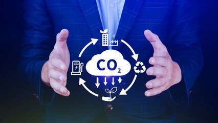 Hand holding CO2 reducing virtual icon for decrease carbon dioxide emission, carbon footprint and...