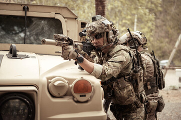 United States Army in camouflage uniforms operation in the forest.with armored vehicle, soldiers...