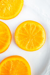 Candied Orange Slices Arranged on a White Ceramic Plate with Dark Background