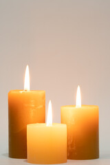 Three burning candles on white background.