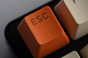 ESC key computer keyboard is orange in closeup.