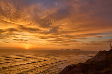 Obraz premium As the sun sets over San Lorenzo Island, the view from Miraflores becomes pure magic .The island silhouettes against a sky ablaze with color, while the ocean whispers of infinite horizons. 