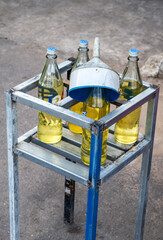 Glass bottles filled with gasoline with a funnel on a road around Kep, Cambodia