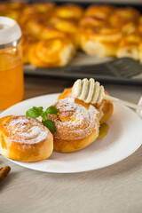 Pastries. Sweet buns with cottage cheese filling and honey in a plate on a wooden table