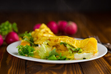 egg roll with sweet pepper and salad, on a wooden table