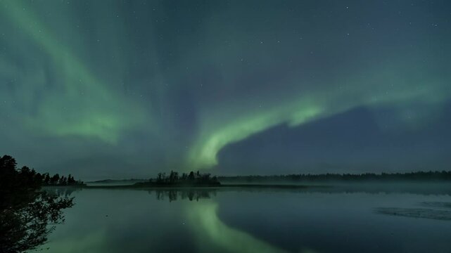 Auroras above a foggy lake, zoom up and back again