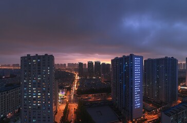 Fototapeta premium Aerial view of a city at night showcasing a solitary apartment building and office towers with illuminated facades, highlighting the vibrant real estate and commercial districts of the urban skyline.