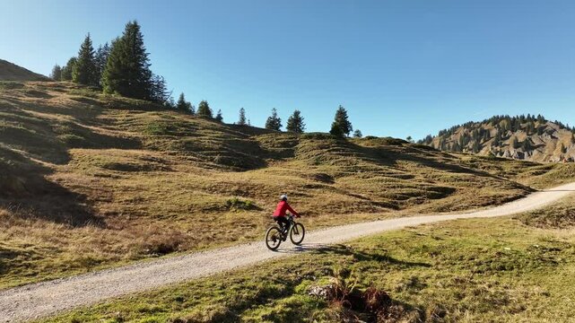 active senior woman cycling with her electric mountain bike in the Bregenz Forest mountains next to Hittisauf, Vorarlberg, Austria