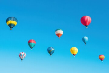 Fototapeta premium Colorful Hot Air Balloons Float Across a Vivid Blue Sky