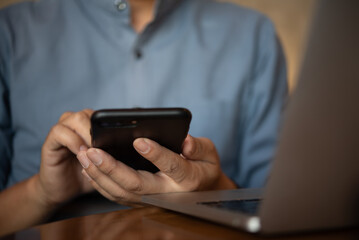 businessman using mobile smartphone with computer laptop in office for networking app social network and email text working