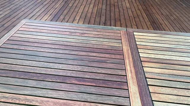 Teak wood table in front of pine deck wood patio behind