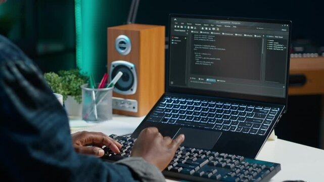 Teleworker in living room office using laptop to do coding for software developing, handheld camera shot. Remote employee typing on device keyboard, solving tasks in apartment, camera A close up
